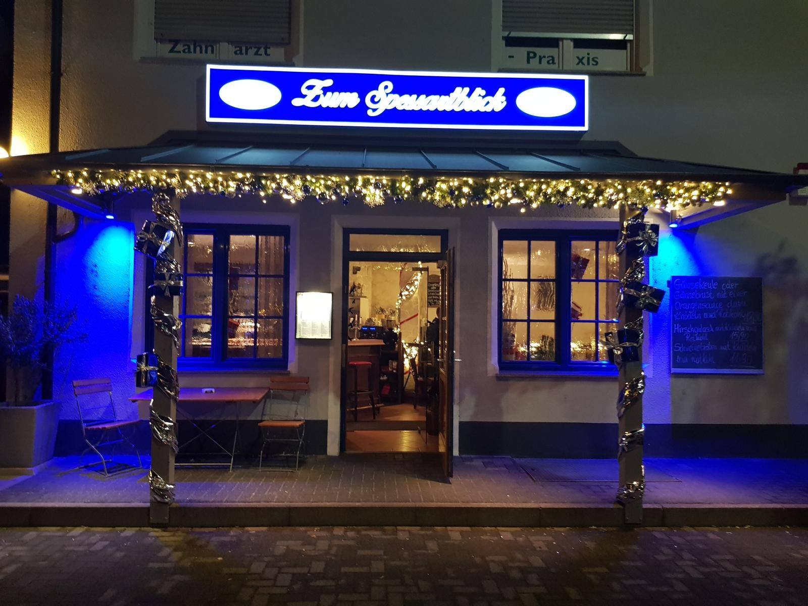 Beleuchteter Eingang des Restaurants Zum Spessartblick am Abend